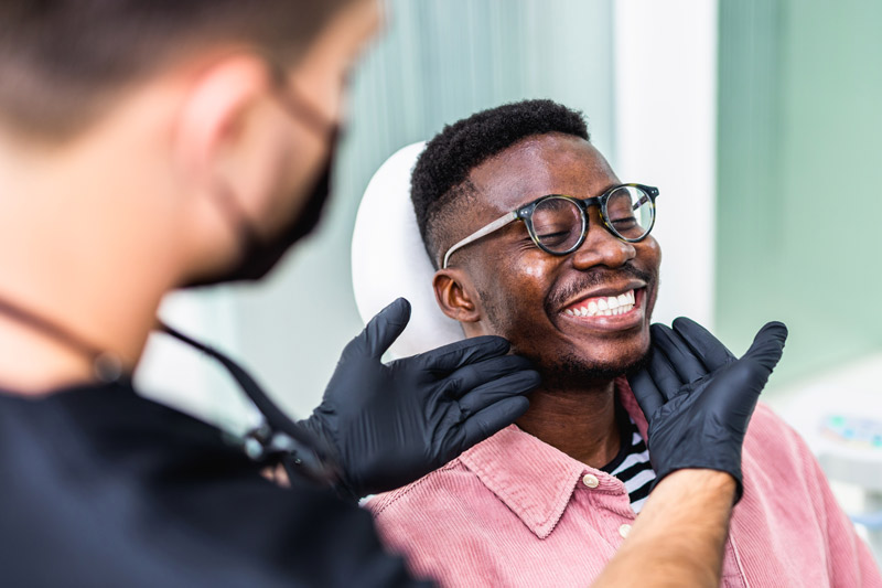 African American young man having a visit at the dentist's. He is sitting on chair at dentist office in dental clinic  in Fairfield County, CT